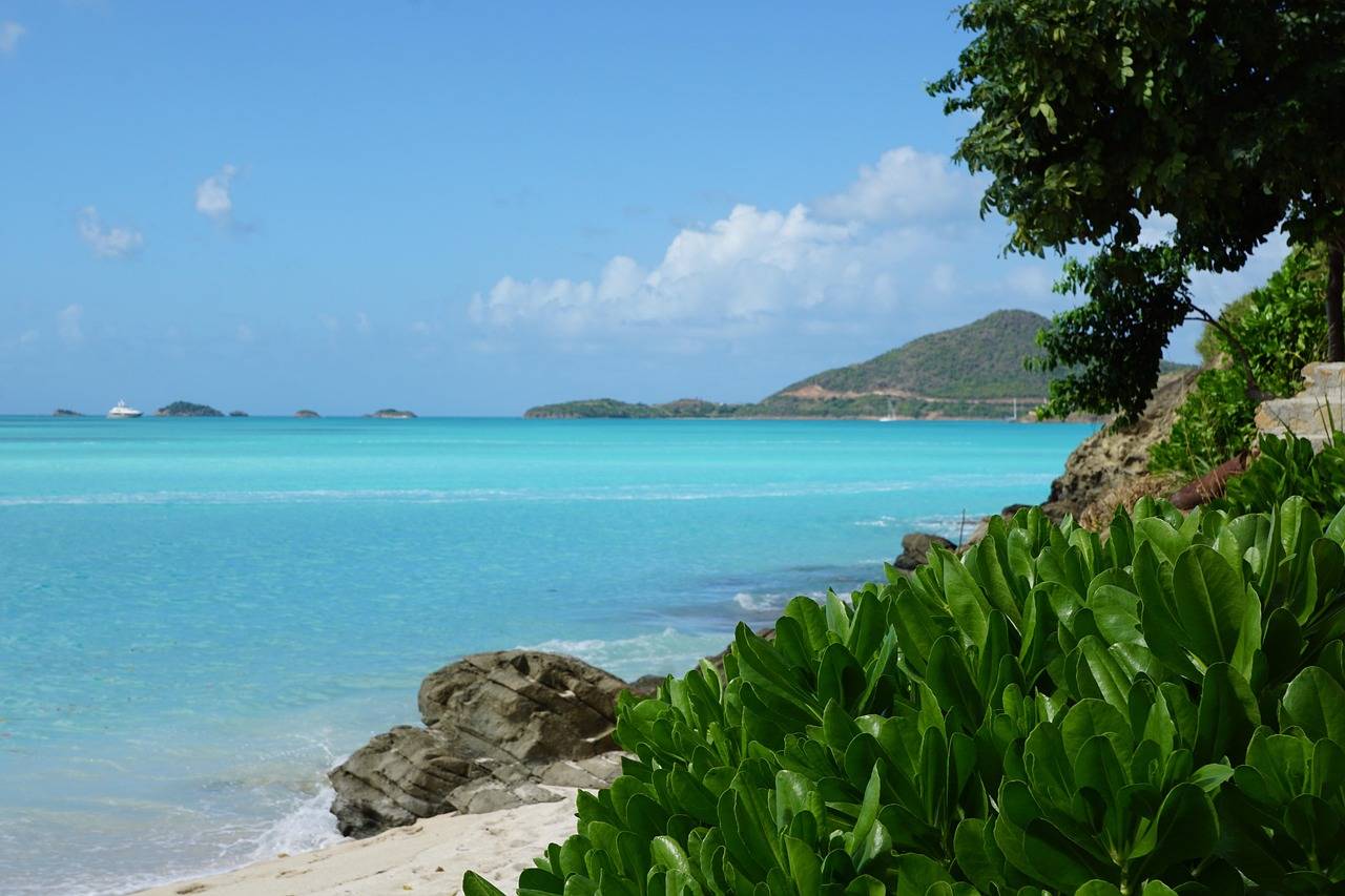 Tyrkysová zátoka a zelené kopce na ostrově Antigua